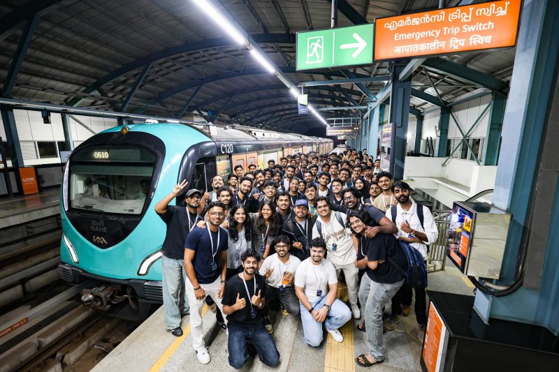 Shayen Thomas and Codex Nightline builders beside a Kochi Metro train after the onboard build sprint